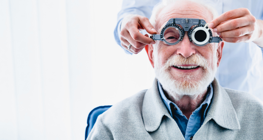 Portrait of a happy mature male patient undergoing vision check with special ophthalmic glasses